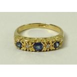 An 18ct gold, sapphire and diamond ring, set with three sapphires divided by two diamonds accents,