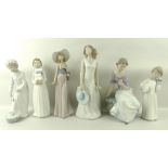 A group of Nao figurines, comprising a boy in nightshirt, a girl in nightgown, a boy carrying books,