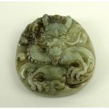A Chinese jade pendant, Qing dynasty, carved with a dragon, 4.5cm diameter.