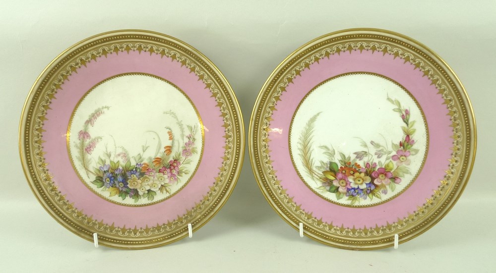 A pair of Royal Worcester porcelain plates, late 19th century, painted with floral central reserves,