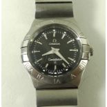 An Omega Constellation wristwatch, with steel casing and wrist band, black face with batons,