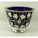 A late 18th century silver basket, of footed vase form, with vine chased and wirework sides,