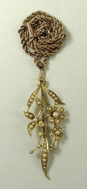 A 15ct gold and seed pearl pendant, formed as a floral corsage of three flowers amongst leaves, 5.