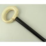 A 19th century walking stick, ebony cane with an ivory cross hatched hoop handle, 93cm.