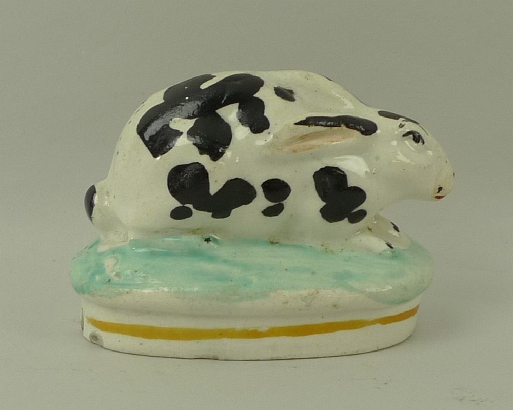 A Staffordshire model of a rabbit, 19th century, on oval base, hand painted black and white, - Image 3 of 4