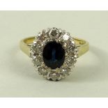 An 18ct gold, diamond and sapphire ring, the central oval cut sapphire surrounded by ten diamonds,