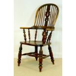 A late 18th century Windsor armchair with outswept broad arms, a stepped back rail,