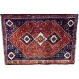 A Shiraz rug with red ground, three central medallions, one cream and two dark blue,