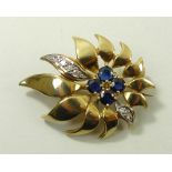 A sapphire and diamond flame flower brooch, with four sapphires to the centre,