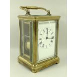 A French carriage clock, brass cased, the white face with Roman numerals,