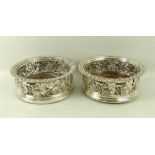 A pair of Regency silver wine coasters, of circular form with pierced vine chased sides,