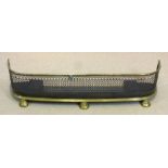 A late Regency brass and pierced steel fender,