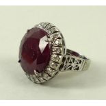 A ruby and diamond dress ring, the central circular stone 18mm, surrounded by twenty four diamonds,