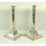 A pair of George III silver candlesticks, in the style of Robert Adam,