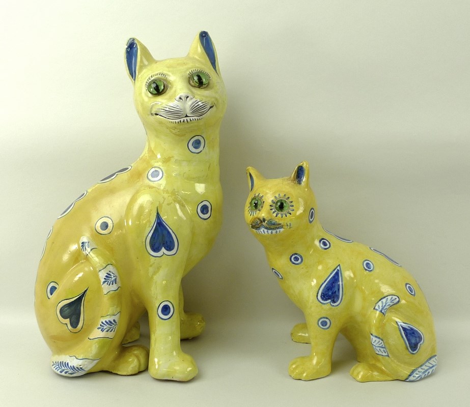 An Emile Galle yellow faience model of a seated cat, late 19th century,