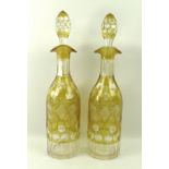 A pair of Bohemian flashed glass decanters, encased amber, decorated with fruiting vines, 36cm.