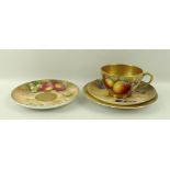 A Royal Worcester trio comprising tea cup, saucer and plate, painted with plums,