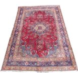 A Tabriz rug, with red ground, central eight pointed star medallions, floral field,