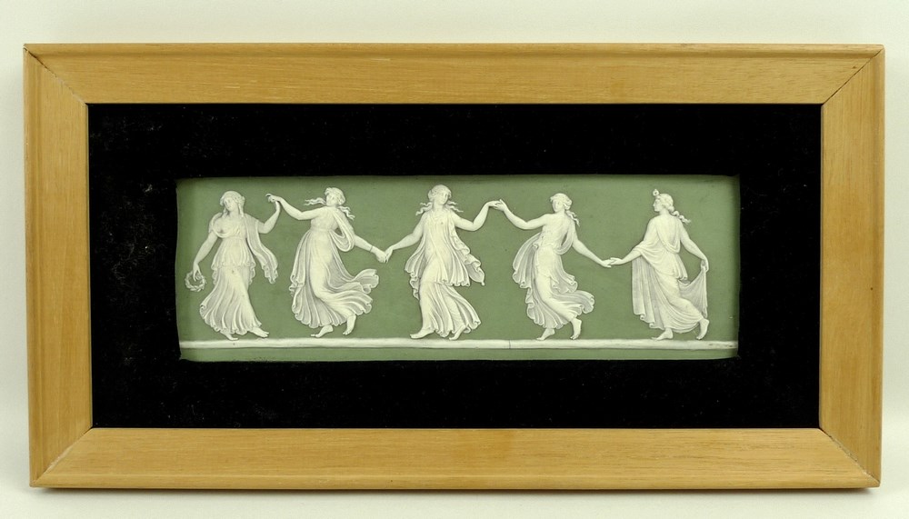 A Wedgwood rectangular plaque depicting dancing girls on an olive green ground, 8 by 23cm.