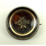 A gold and silver pique work tortoiseshell button brooch of circular form, 3cm.