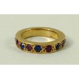 A gold eternity ring, set with red and blue corundums, size J, 7.