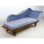 An Edwardian stained mahogany chaise longue, with shaped back, scroll over arm,