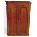 A Victorian oak corner cupboard, cornice over twin flat fronted doors and three fixed shelves,