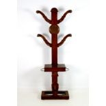 An oak hall stand, circa 1910, with four shaped branch arms with eight turned court pegs,