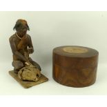 A papier mache figurine, 19th century, of a native bird seller kneeling with basket,