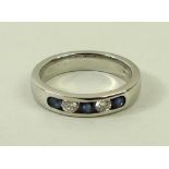 A platinum, diamond and sapphire ring, with three sapphires set into the ring,