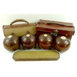 A numbered set of four lignum vitae bowling balls, with inset ivory, Taylor Rolph and Co Ltd,