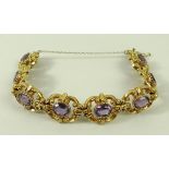 A 9ct gold and amethyst bracelet, of eight scrolled cartouche shaped links,