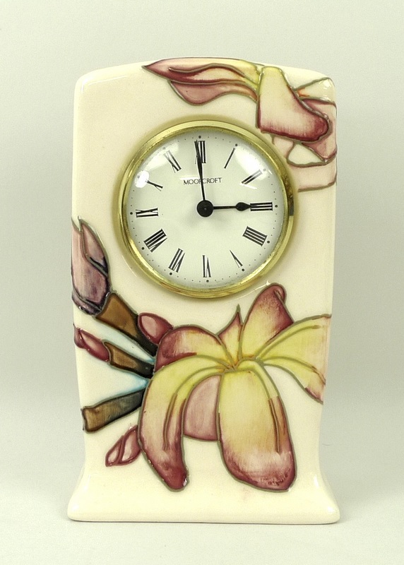 A Moorcroft mantel clock, in magnolia pattern, the circular face with Arabic numerals,