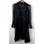 An early 20th century black dress coat, of self striped chiffon, with silk satin braided bodice,