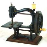 SEWING MACHINE. 12ins tall, cast iron on wooden base, black with traces of gold decoration, hand