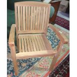 A set of four 20th century teak open armchairs.