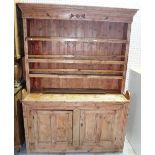 A 19th century and later Irish style pine dresser, the three tier plate rack over two cupboards,