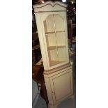 A cream painted corner cupboard.