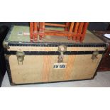 A travel trunk with Cunard baggage labels, containing two bowler hats, a top hat and a Teddy bear.