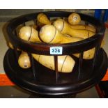 A quantity of wooden skittles, a circular ebonised stand, and two hazel wood metamorphic spheres.