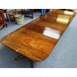 A Regency style mahogany triple pillar dining table on twelve downswept supports, two extra leaves,