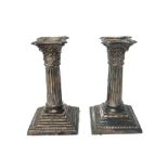 A pair of silver candlesticks, each of Corinthian column form, on a stepped square base,