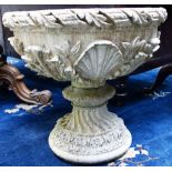 A pair of reconstituted stone circular planters with floral moulded bodies on spiral fluted socles,