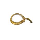 A gold bracelet, in an interwoven link design, on a snap clasp,