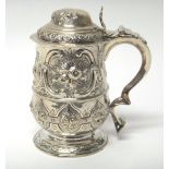 A George III silver tankard of baluster form, with later embossed decoration, London 1784,