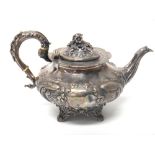 A Victorian silver teapot of squat melon form, with embossed floral decoration and scroll handle,