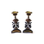 A pair of Regency style gilt and patinated bronze candlesticks, each on triform bases,