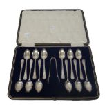 A set of twelve silver coffee spoons and a matching pair of sugar tongs, Sheffield 1921, cased,