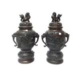 A pair of Japanese bronze vases and covers, Meiji period, set with animal mask handles,