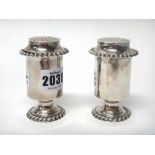 A pair of late George III silver pounce pots, each of cylindrical form,